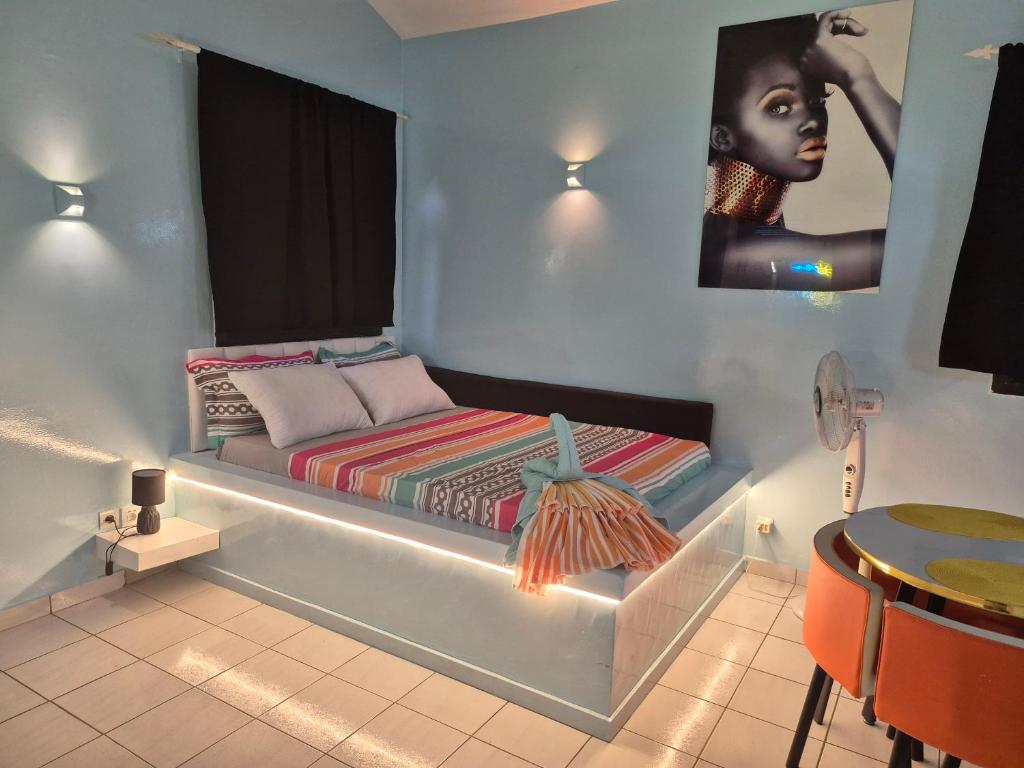 una camera da letto con un letto con una donna sul muro di Studio Lipstick a Saly Portudal