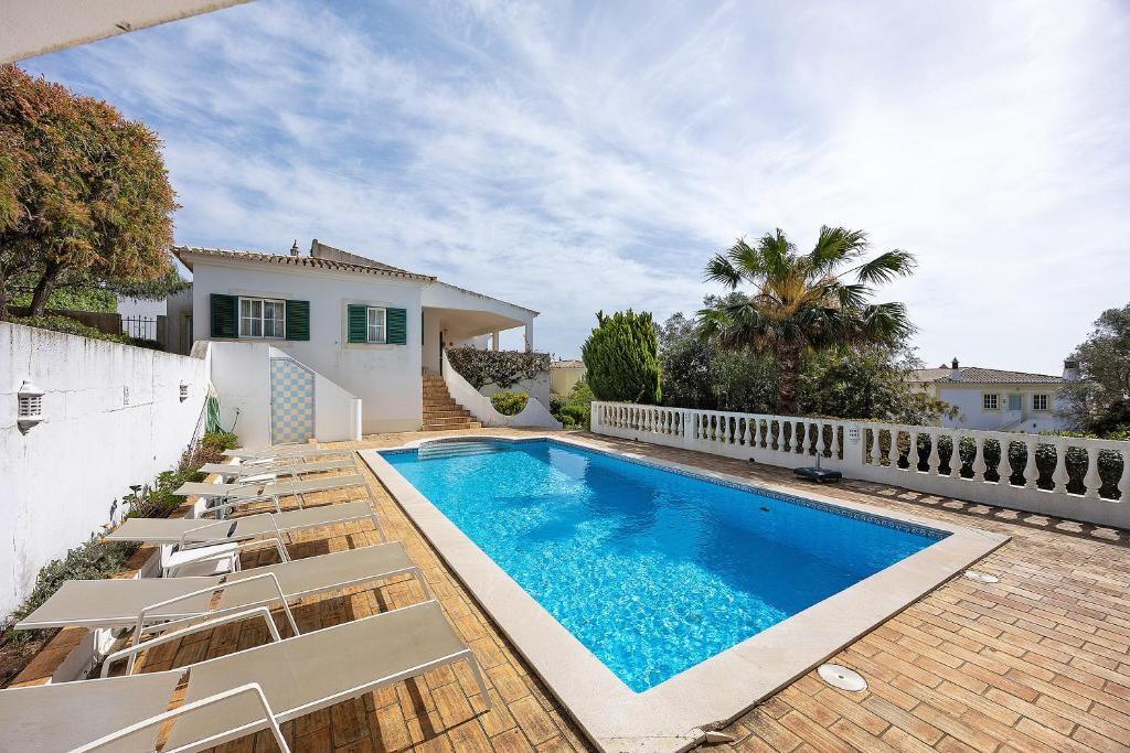 a swimming pool with lounge chairs next to a house at Monte Lemos Villa 35 in Luz