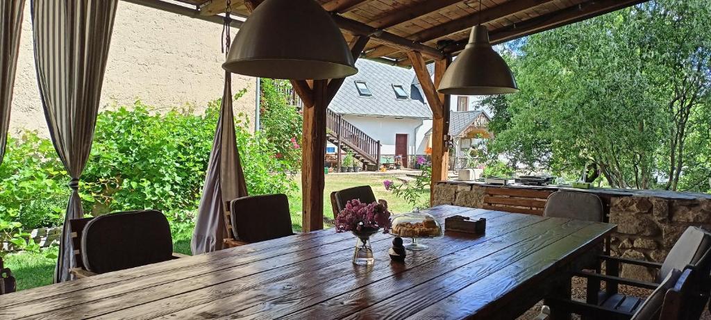a wooden table on a patio with chairs and lights at Farma U Nýdrlů in Stará Červená Voda