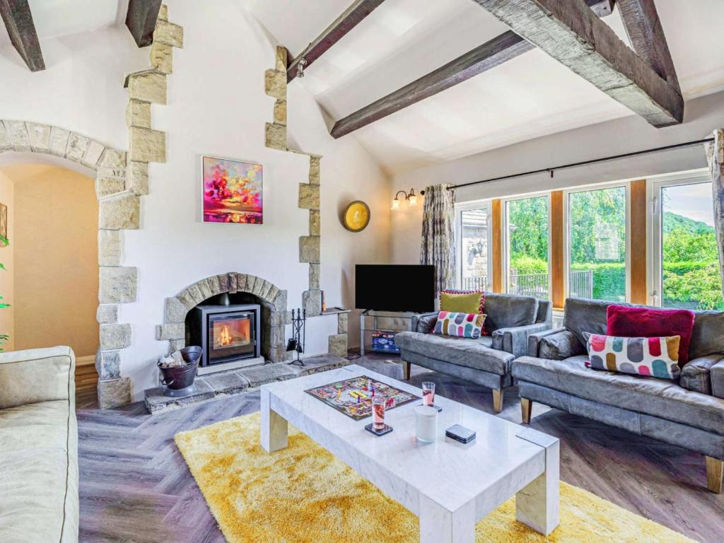 a living room with a couch and a fireplace at 4 Bed in Skipton oc-89095 in Starbotton
