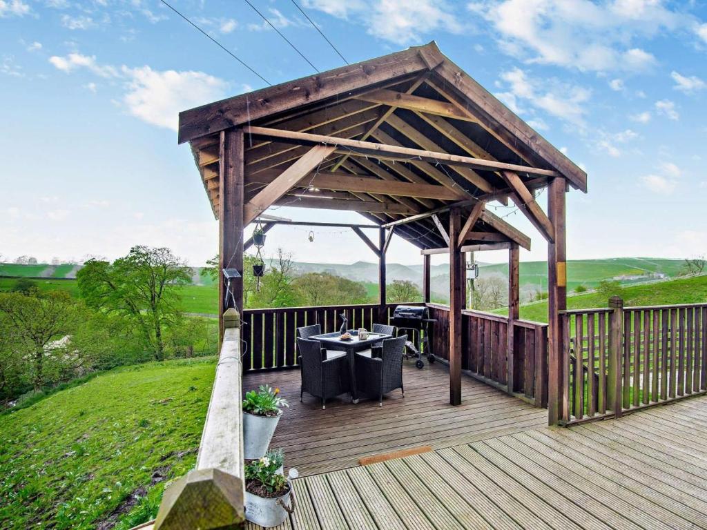 a wooden gazebo with a table on a deck at 2 Bed in Leek oc-52923 in Grindon