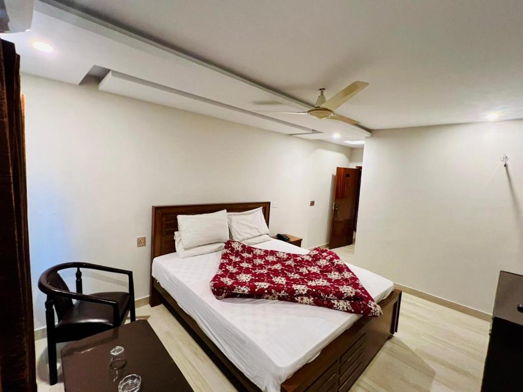 a bedroom with a bed with a red pillow on it at Citymax Hotel in Rawalpindi