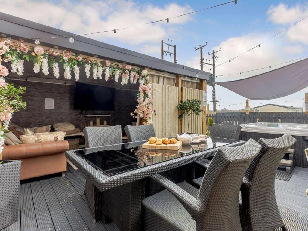 a patio with a table and chairs on a deck at 5 Bed in Pershore oc-91349 in Peopleton