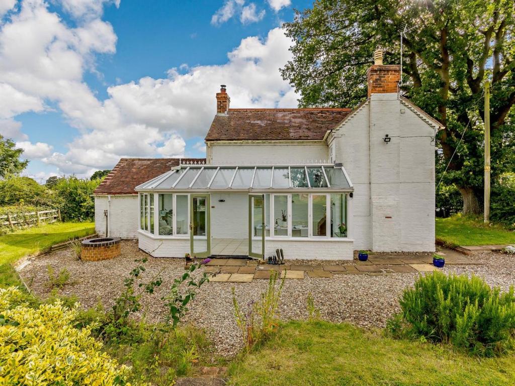a white house with a conservatory in a garden at 3 Bed in Pershore oc-92975 in Eckington