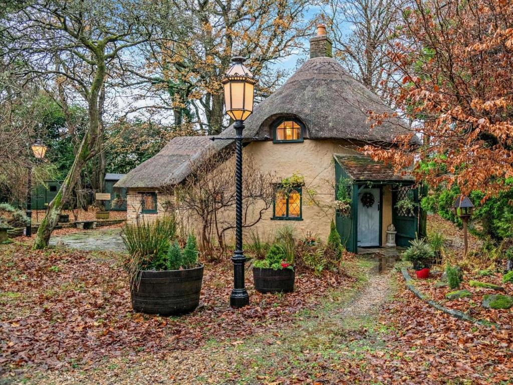 een huis met een straatlantaarn ervoor bij 2 Bed in Wareham oc-79305 in East Stoke