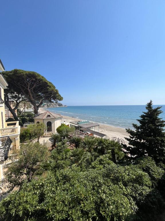 a view of a beach with a house and the ocean at Hotel Gandolfo in Alassio