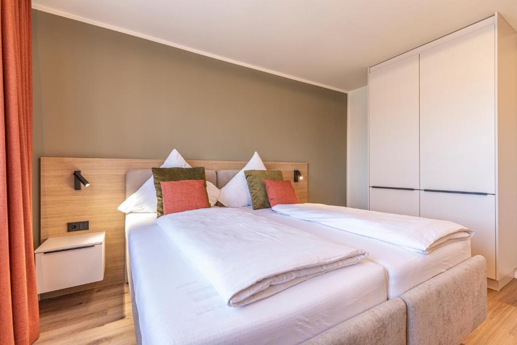 a bedroom with a bed with white sheets and pillows at Starzel Rooms in Alling