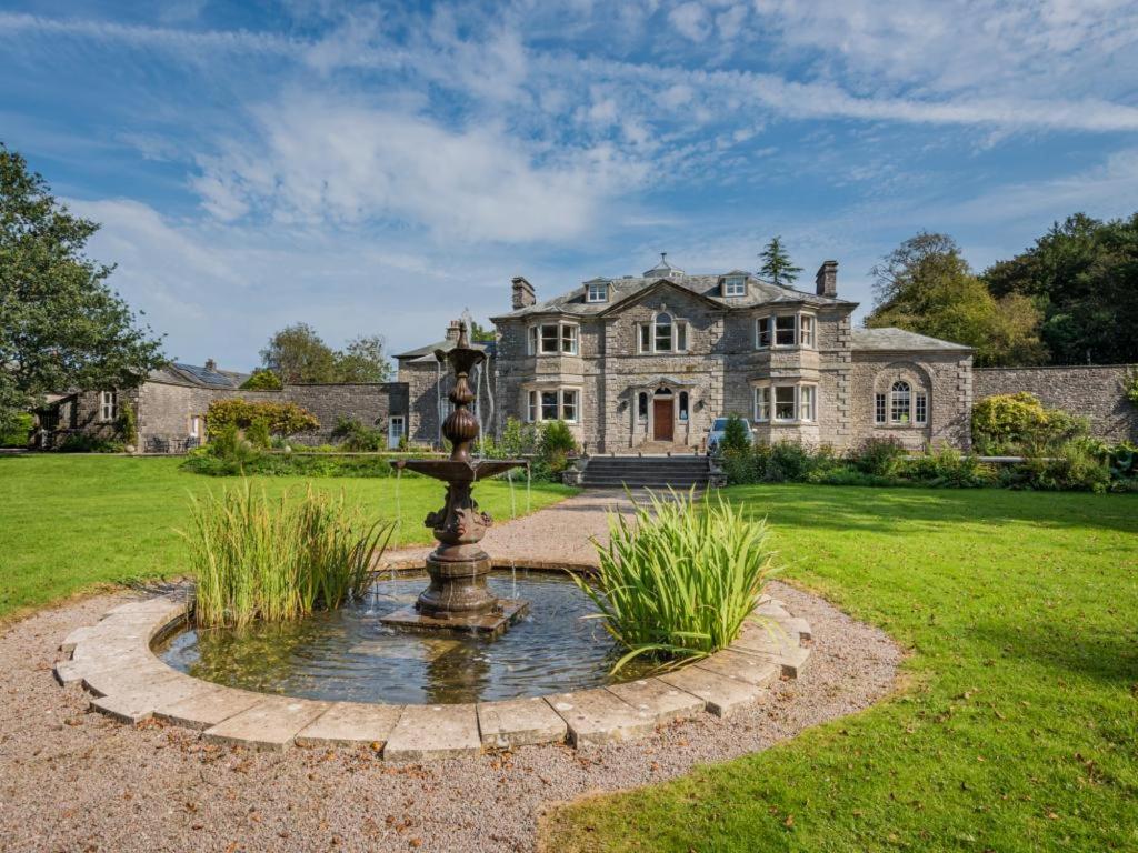 a large stone house with a fountain in the front yard at 1 Bed in Penrith oc-sz350 in Orton