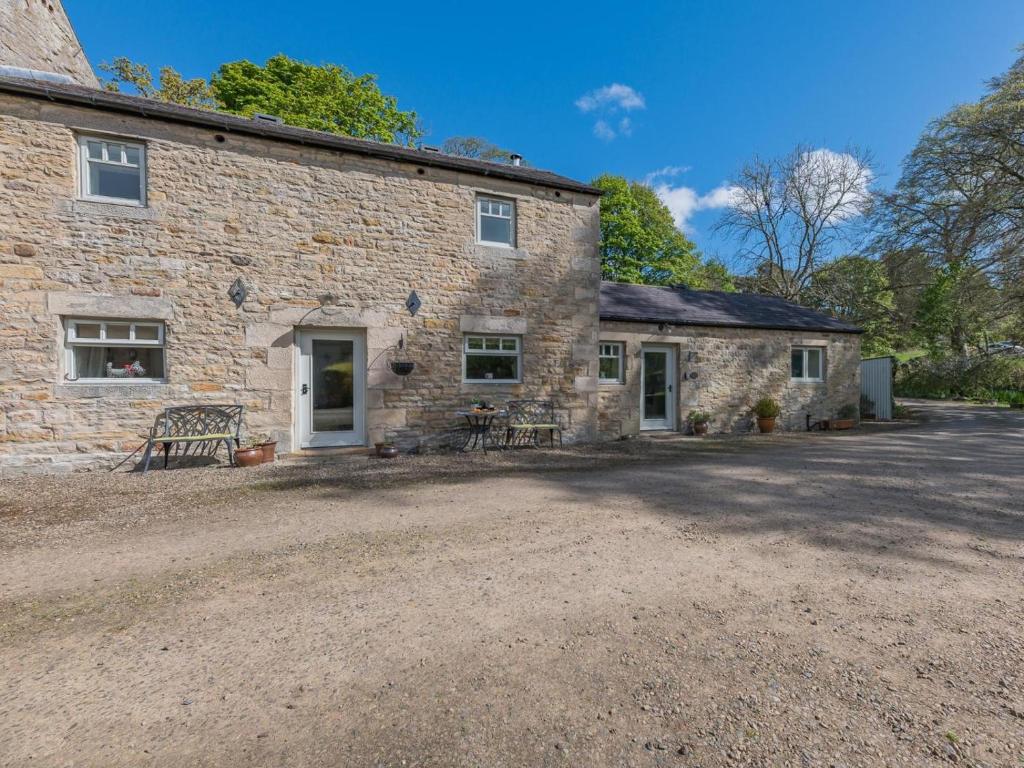 a stone house with a gravel driveway in front of it at 3 Bed in Hexham oc-96038 in Bardon Mill
