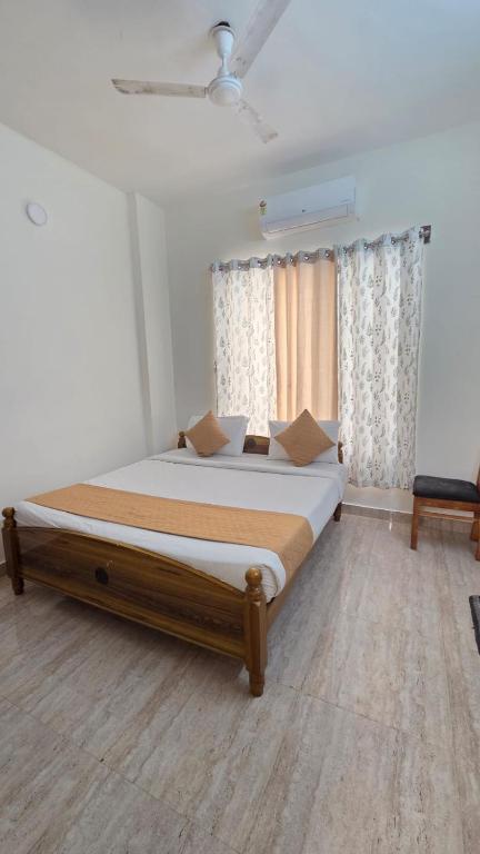 a bedroom with a large bed in front of a window at Noble Grand Villa in Mahabalipuram
