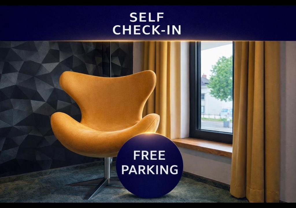 a orange chair sitting next to a window with a free parking sign at PAULINEN Residenz Komfortabel wohnen - Flexibel ankommen in Detmold
