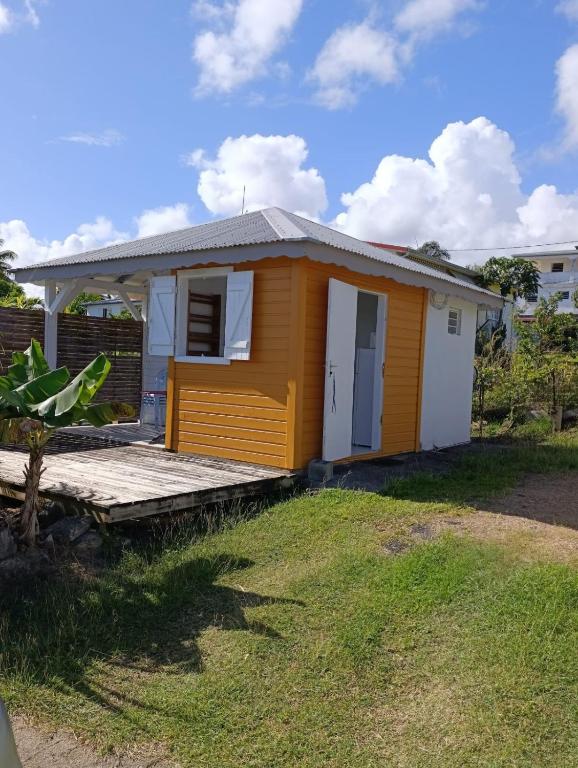 a small yellow house with a porch at Chez Patrick in Sainte-Rose
