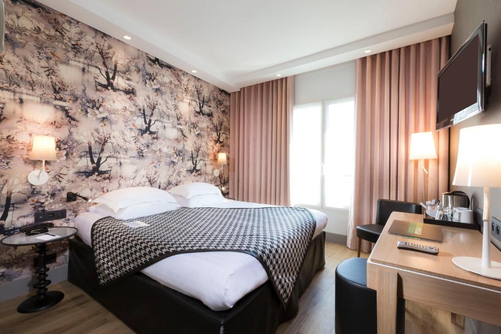 a hotel room with a bed and a desk at Hôbou - ex Hotel Acanthe in Boulogne-Billancourt