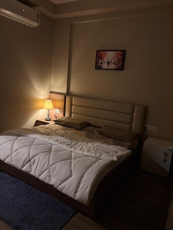 a bedroom with a large white bed in a room at Aarcos Stays in Greater Noida