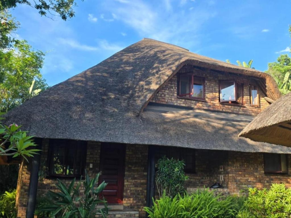 a house with a thatched roof at Kruger park lodge 503 in Hazyview