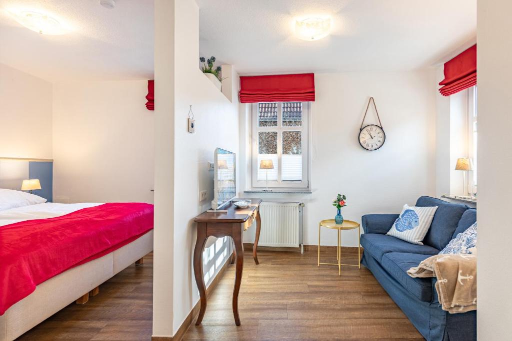 a bedroom and a living room with a bed and a couch at Dat lütte Huus - Wohnung 2 in Husum