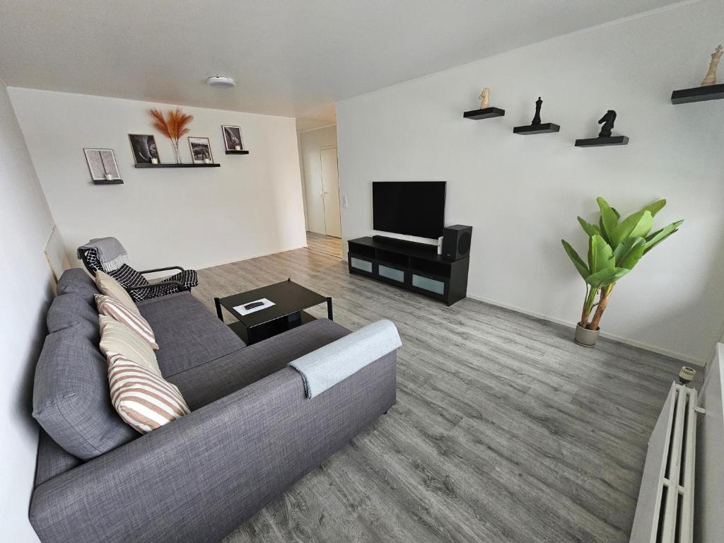 a living room with a gray couch and a television at Lappi in Tornio