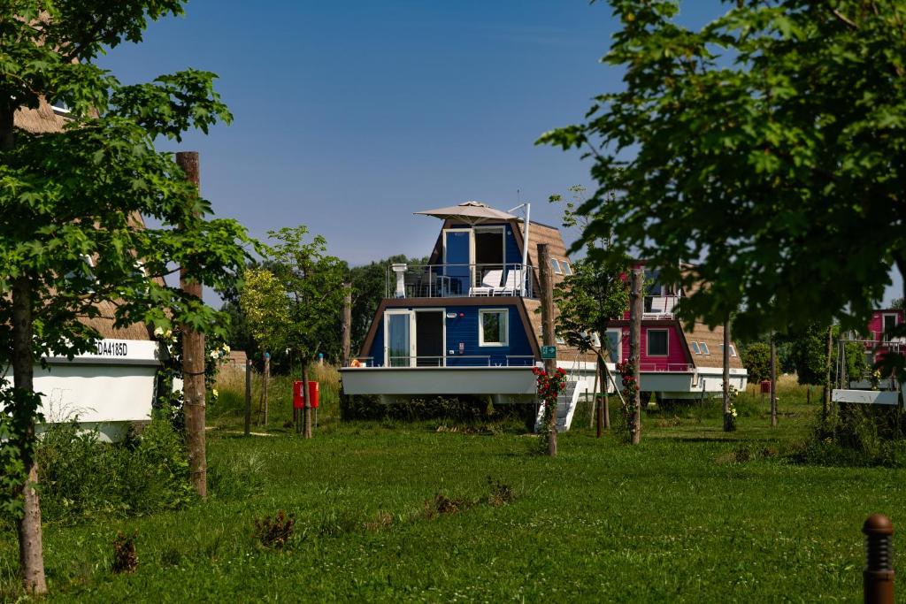 a boat is sitting in the grass near some houses at Bungalow Marina Azzurra in Lignano Sabbiadoro