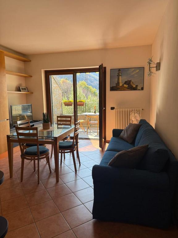 a living room with a blue couch and a table at Casa Alba sul Lago in Dervio