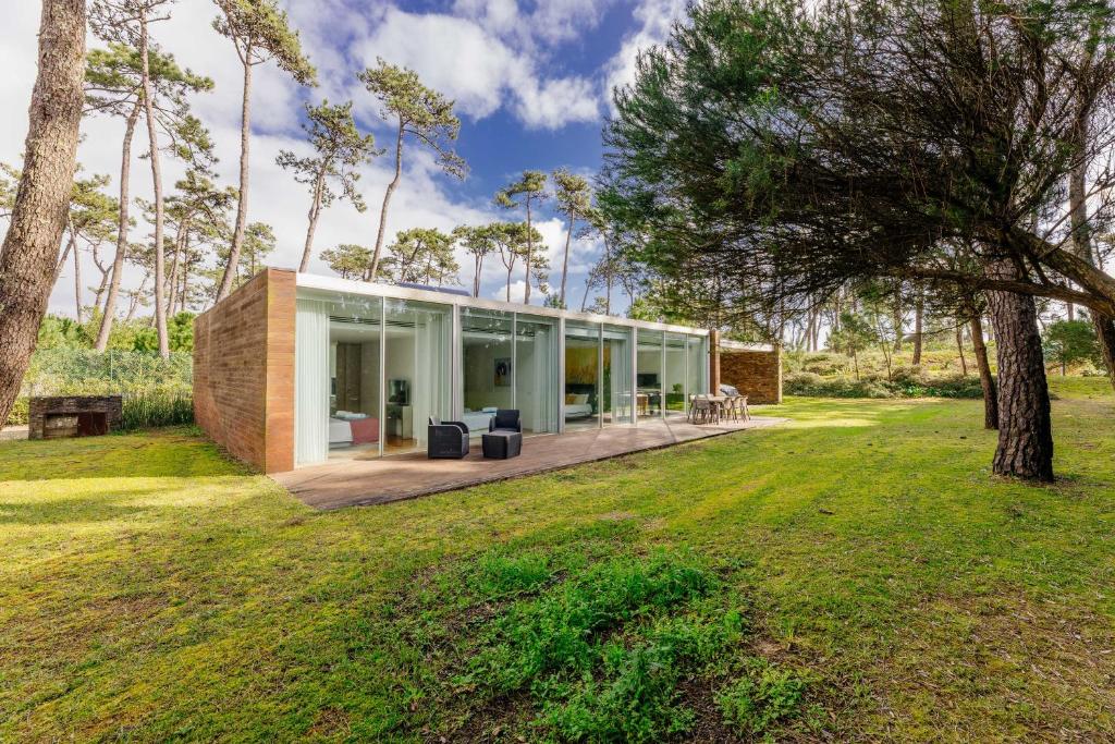 a house with glass walls and a yard at BestVillas Park Ofir in Esposende