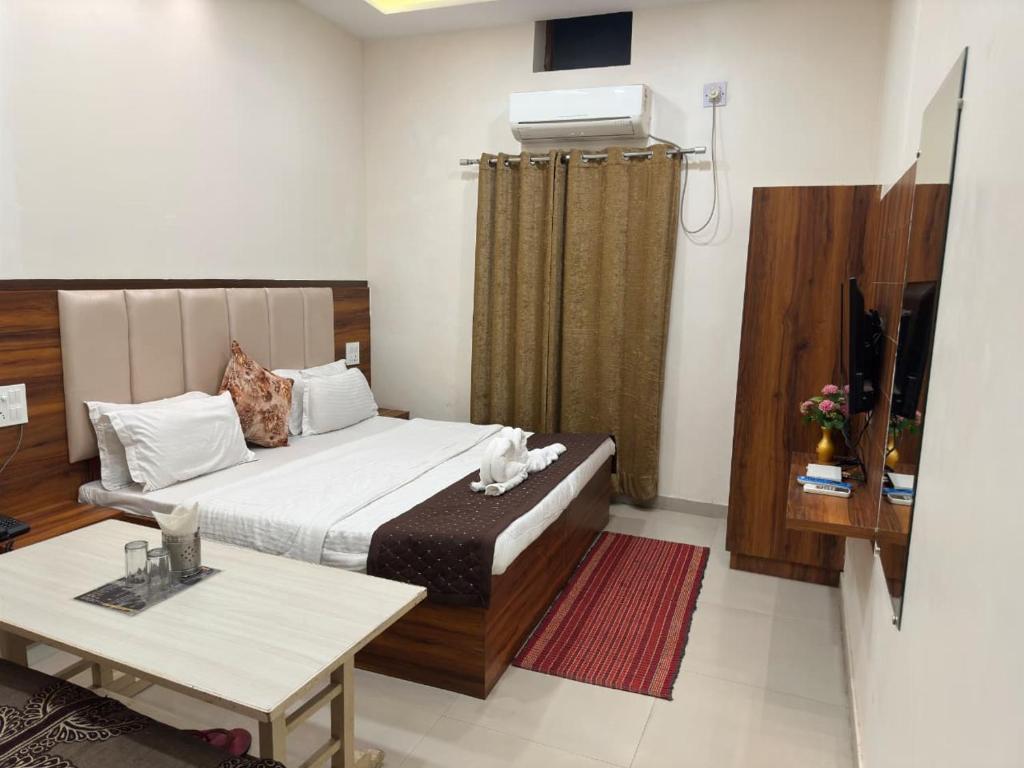 a bedroom with a bed and a table in it at Mithilesh Hotel in Kaithal