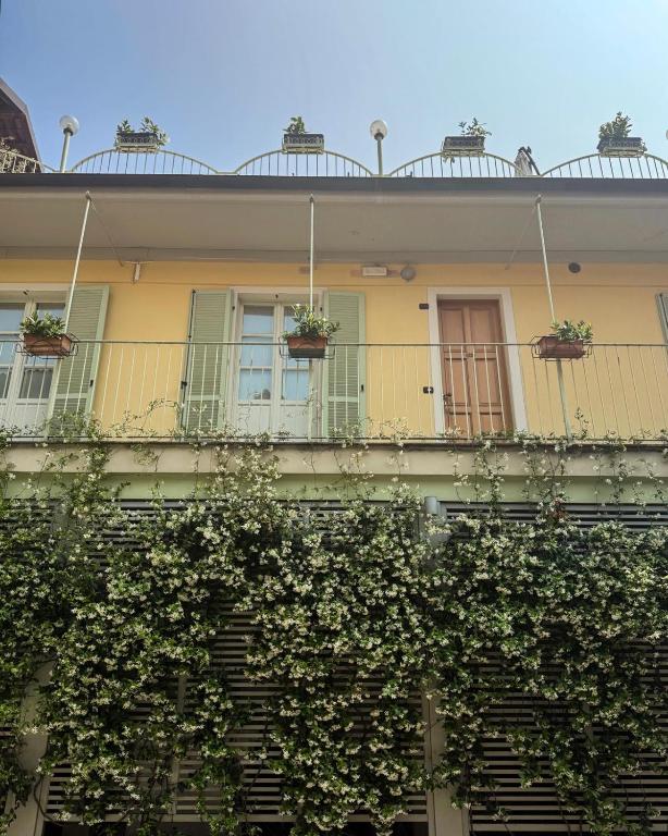 a yellow building with windows and plants on it at Albergo Ristorante Badellino dal 1917 in Bra
