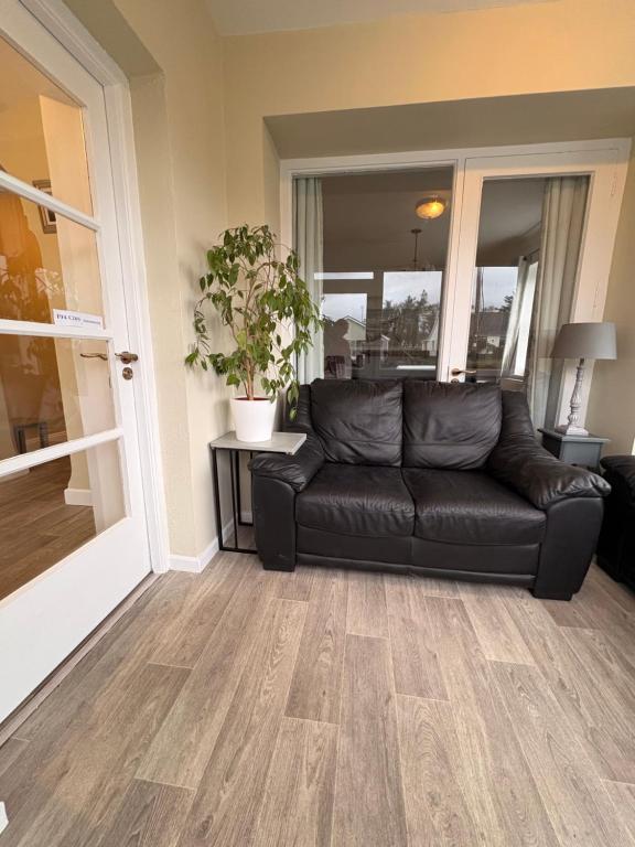 a black leather couch in a living room at The Townhouse Dungloe in Dungloe