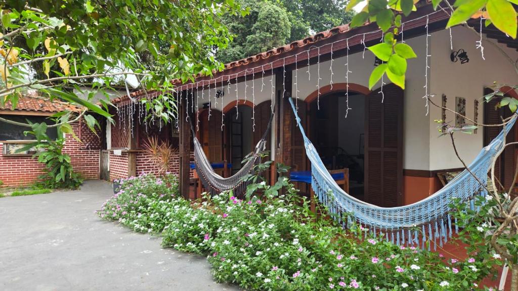 a house with hammocks on the side of it at Pousada Maria de Lino in São Sebastião
