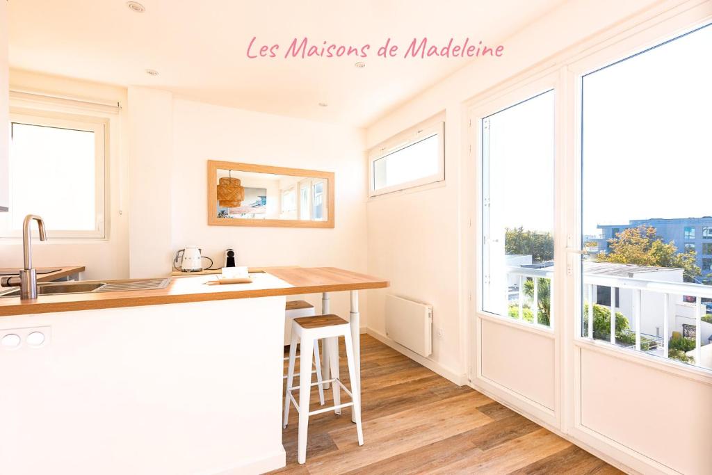 a kitchen with white walls and windows and a counter at L'Embrun - Plage, port et marché à deux pas in Pornichet