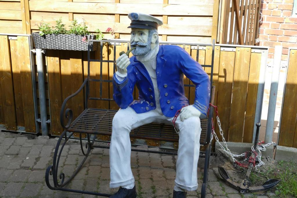 a statue of a man sitting on a bench at Kapitänshaus Schäfer App Bootsmann in Brunsbüttel