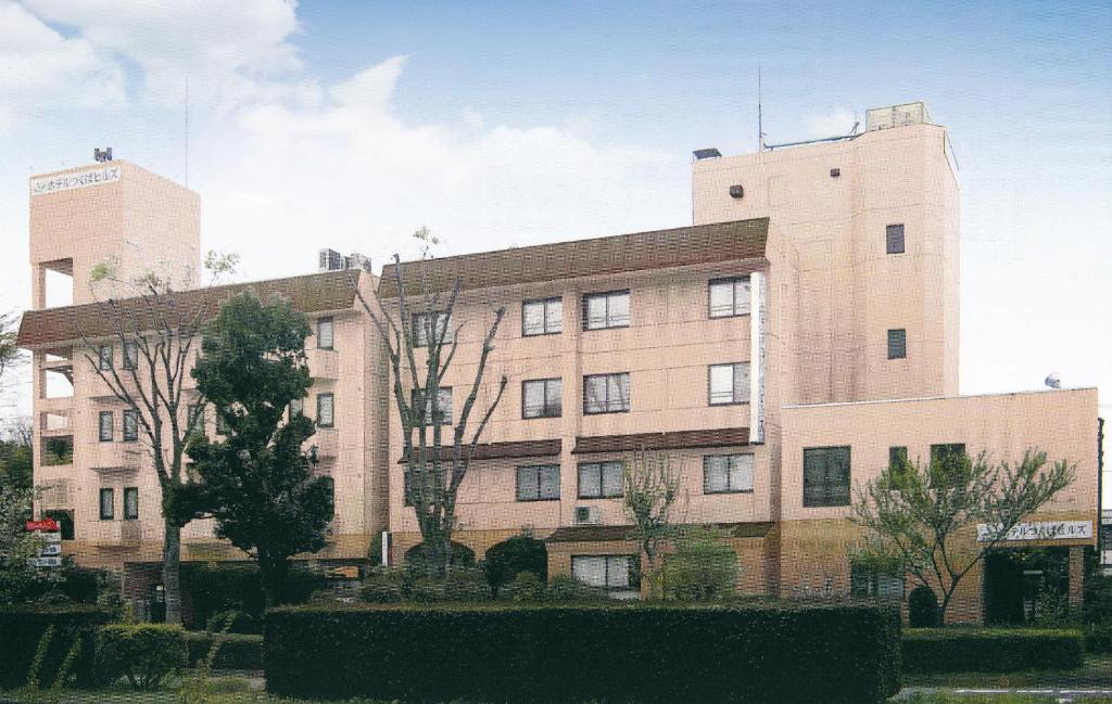 a large brick building with trees in front of it at Hotel Tsukuba Hills Gakuen-odori in Tsukuba