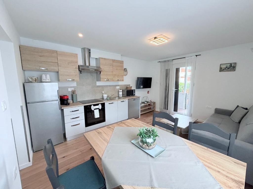 a kitchen and living room with a table and chairs at A & B apartment in Lovran