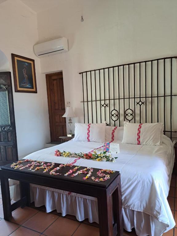 a bed with a table with flowers on it at Casa de Siete Balcones Hotel Boutique in Oaxaca City