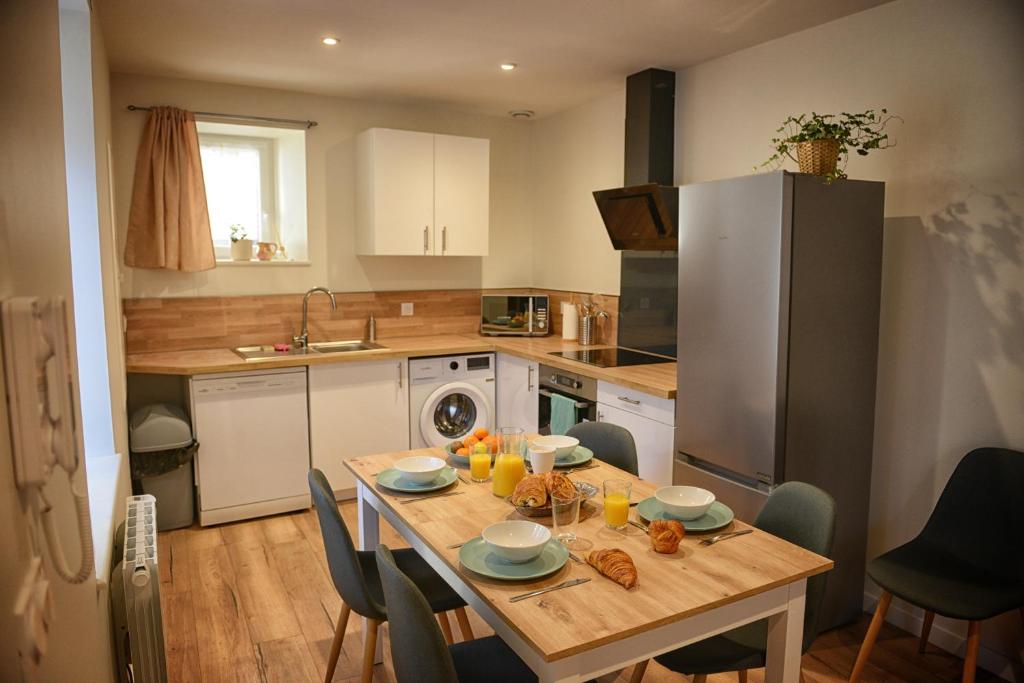 a kitchen with a table with food and drinks on it at Fleur des Vents in Saint-Flour