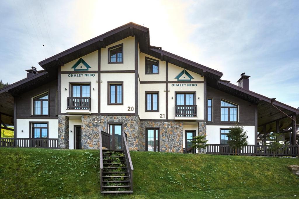 a large house on top of a green hill at CHALET NEBO in Bukovel