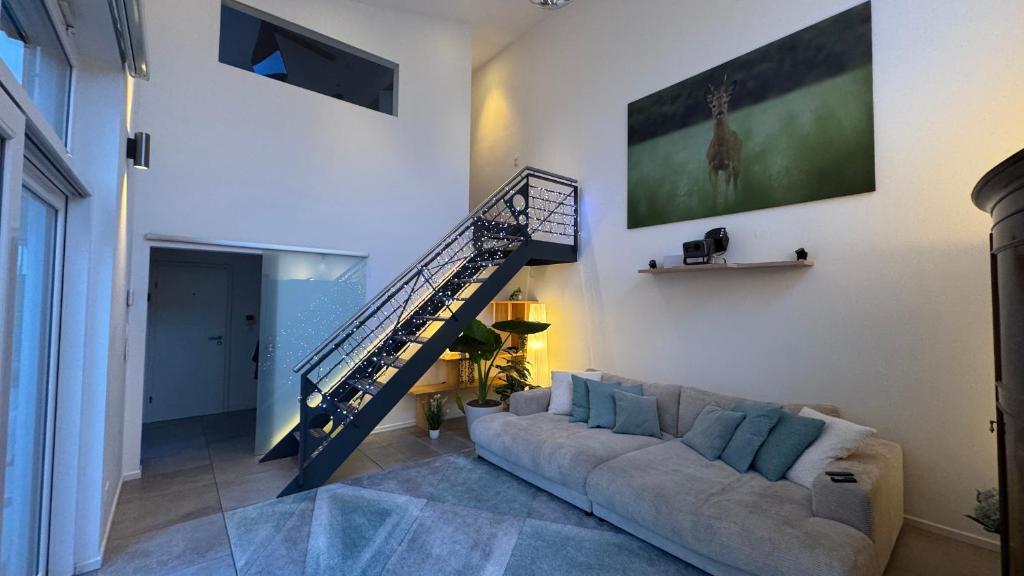 a living room with a couch and a staircase at Exklusives Architektenhaus, Pool und Privateinfahrt in Mönchengladbach