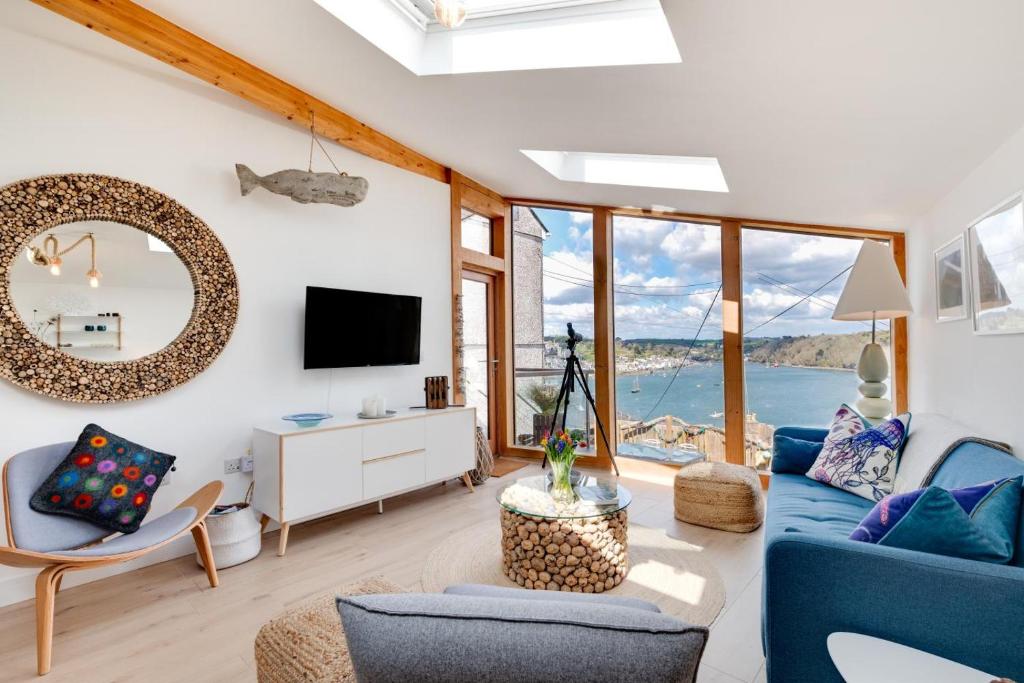 a living room with a blue couch and a mirror at 2 Bed in Polruan oc-p00896 in Polruan