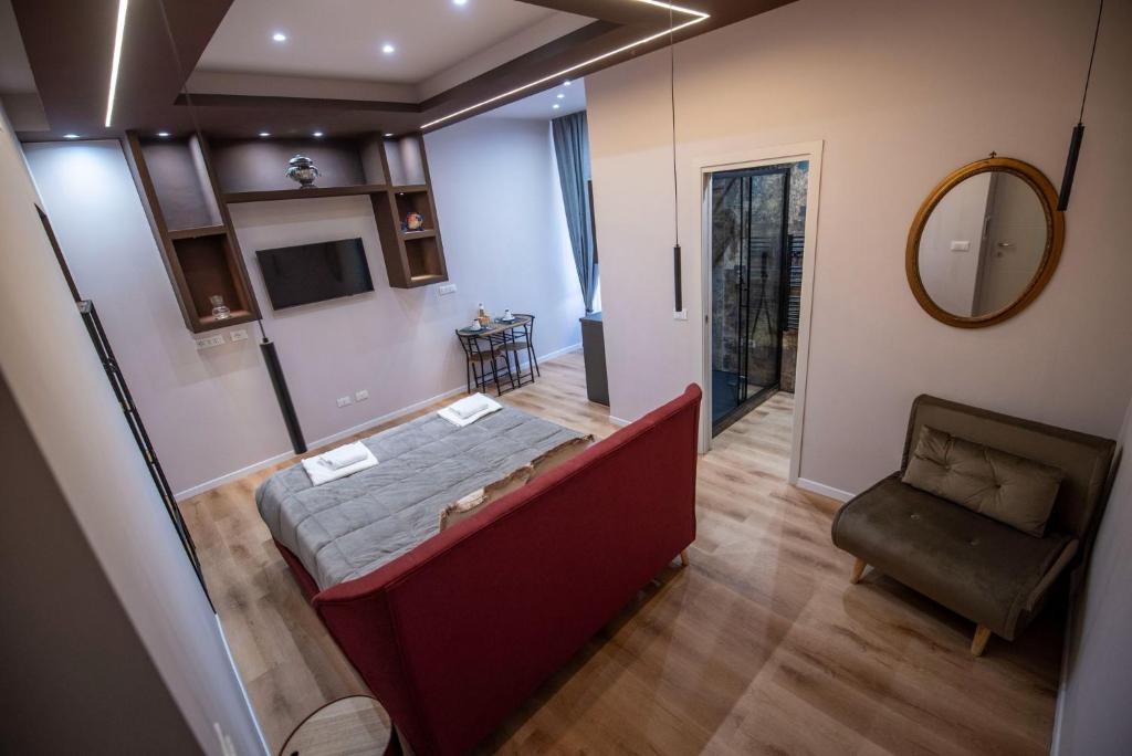 a room with a bed and a chair and a mirror at Assarotti Luxury Suite in Genoa