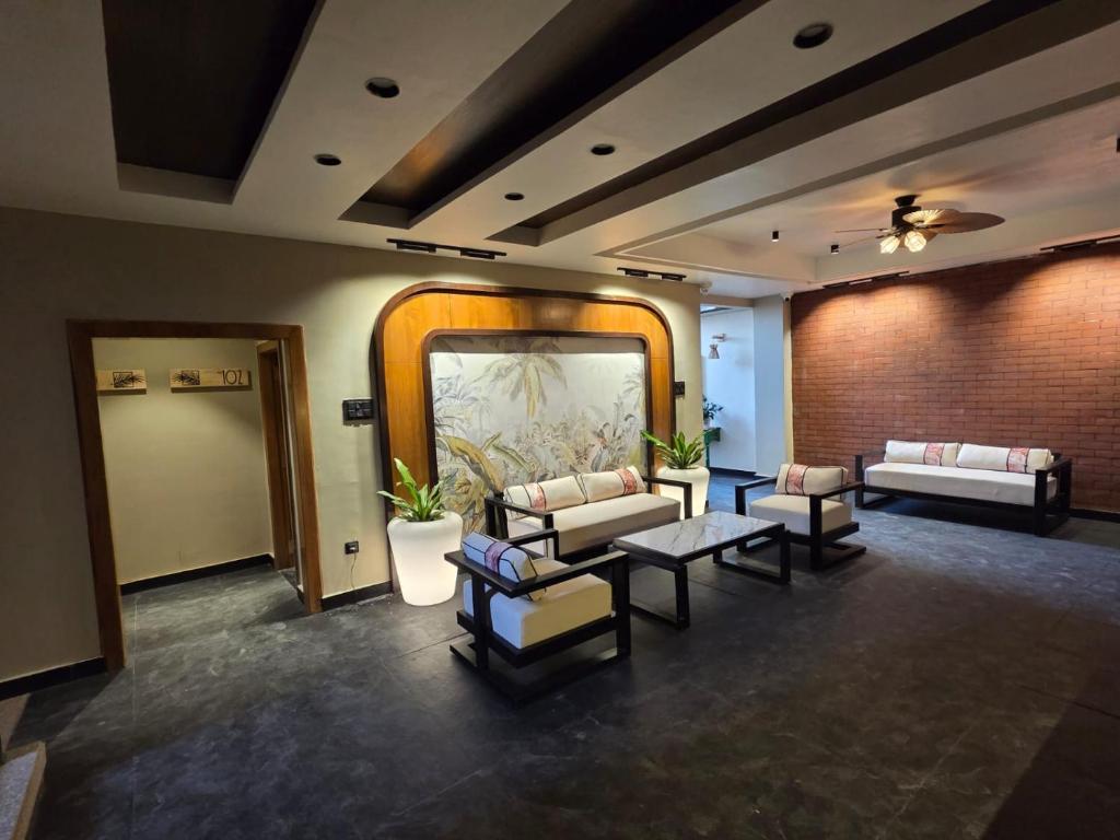 a lobby with couches and chairs and a mirror at ANVI Homestay in Bhopal