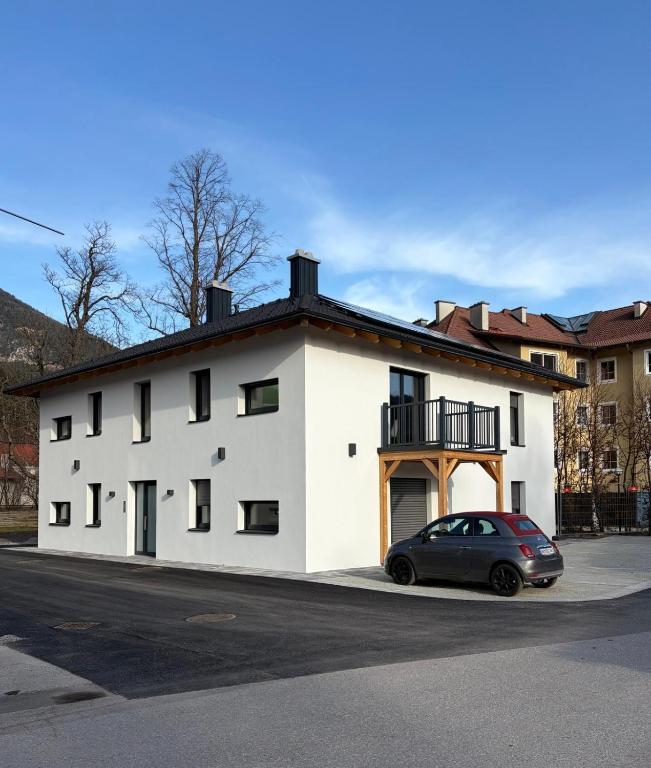 a white building with a car parked in front of it at Pollross Apartments in Reichenau