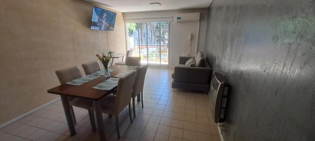 a dining room with a table and chairs and a window at Depto 75m 2 dormitorios Frente al Parque Central con Cochera en el Centro denMendoza in Mendoza