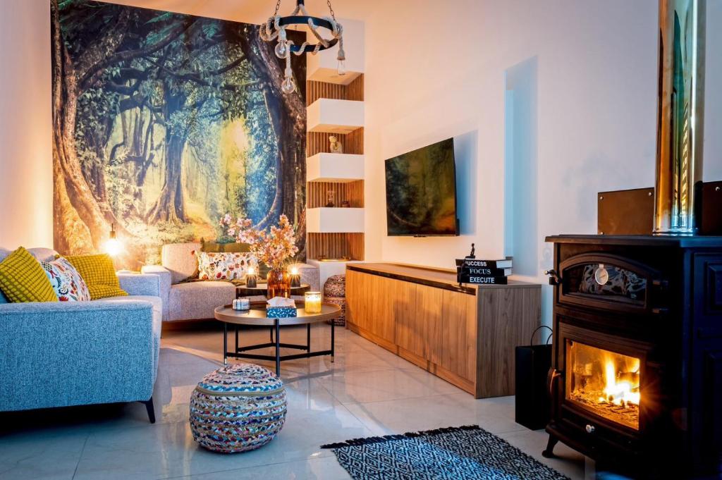 a living room with a fireplace and a large painting at Katherine's Village House in Ayios Ioannis