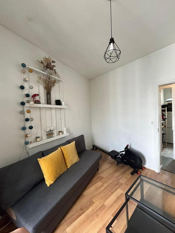 a living room with a couch and a glass table at Sejour paris parc des expositions in Vanves