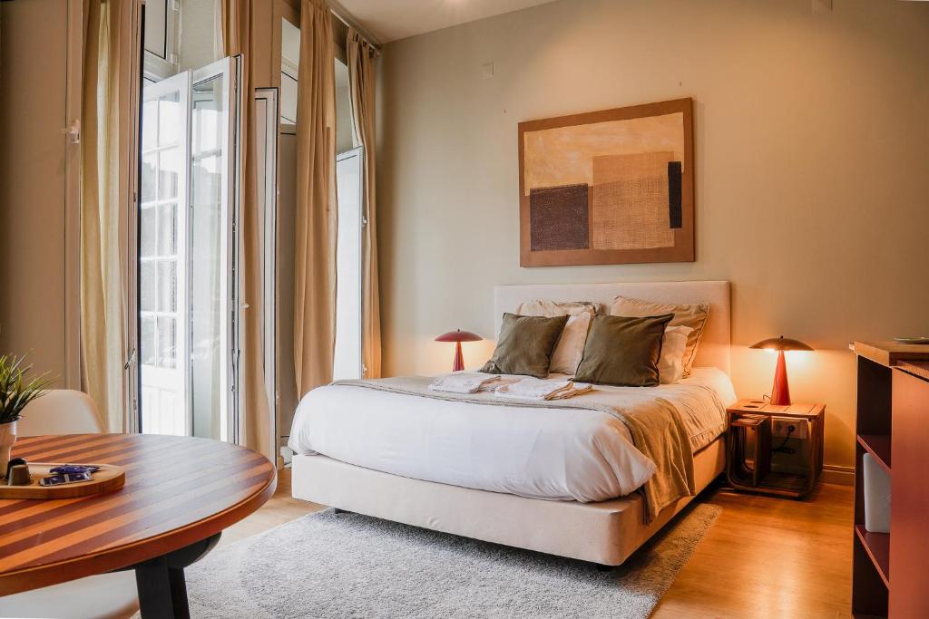 a bedroom with a white bed and a table and a table sidx sidx at Impar Studios in Porto