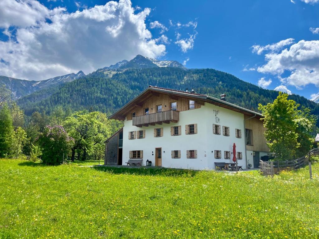 Ein Haus auf einem Feld mit Bergen im Hintergrund in der Unterkunft Hof Ida in Bach