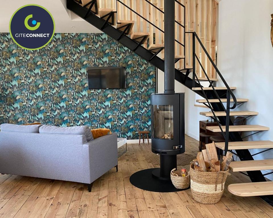 a living room with a fireplace and a couch at La GRANGE BY CARO in Cantoin