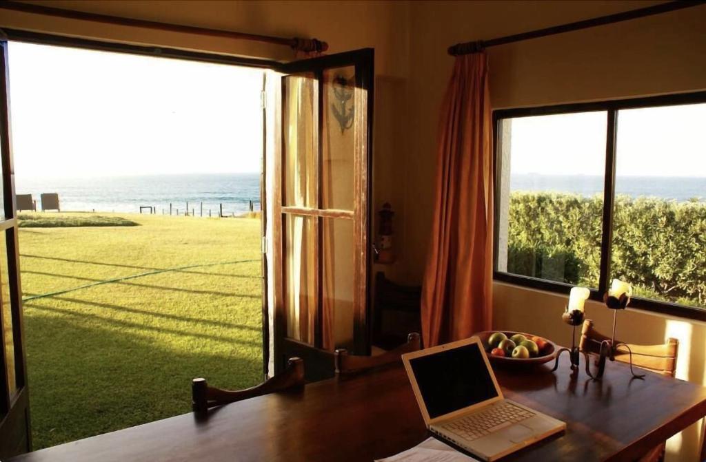 a laptop sitting on a desk in front of a window at 4Sea House in Porto Covo
