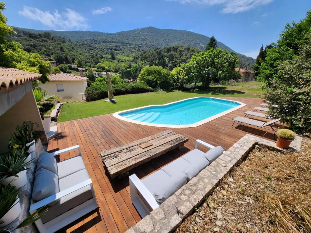 a backyard with a swimming pool and a wooden deck at happyfew villa laghet in La Trinité