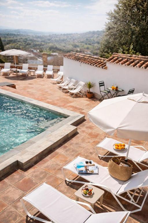 a villa with a swimming pool and lounge chairs at Galteo Almendra - Pool in Ronda