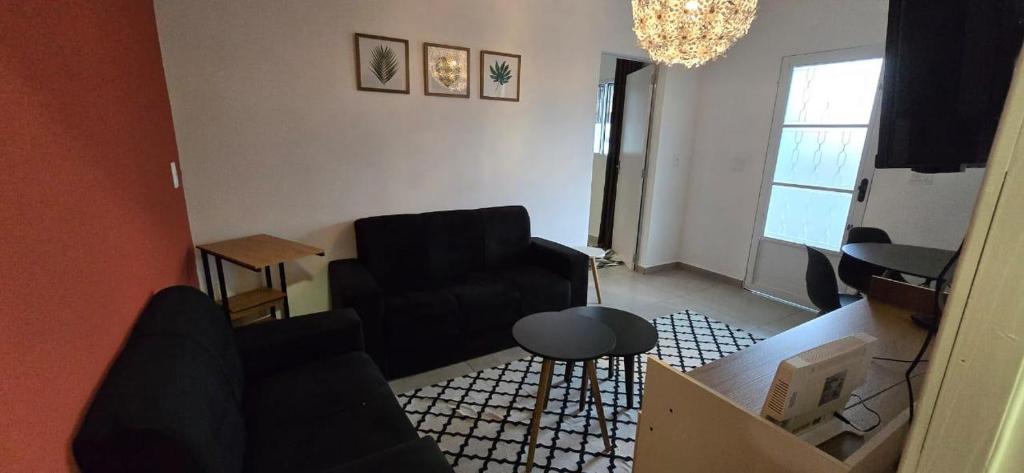 a living room with a couch and a chair at Apartamento Estilo Moderno in Belo Horizonte